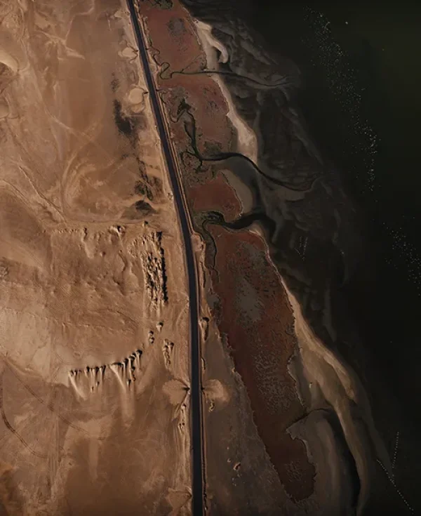 Aerial view of a road next to the brown sand and ocean on the Skeleton Coast, Namibia Aerial view of a road next to the brown sand and ocean on the Skeleton Coast, Namibia